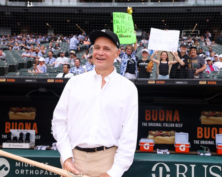 Michael Bishop, MD at the game where the White Sox Charities gift was announced, with some of his patients in the background.