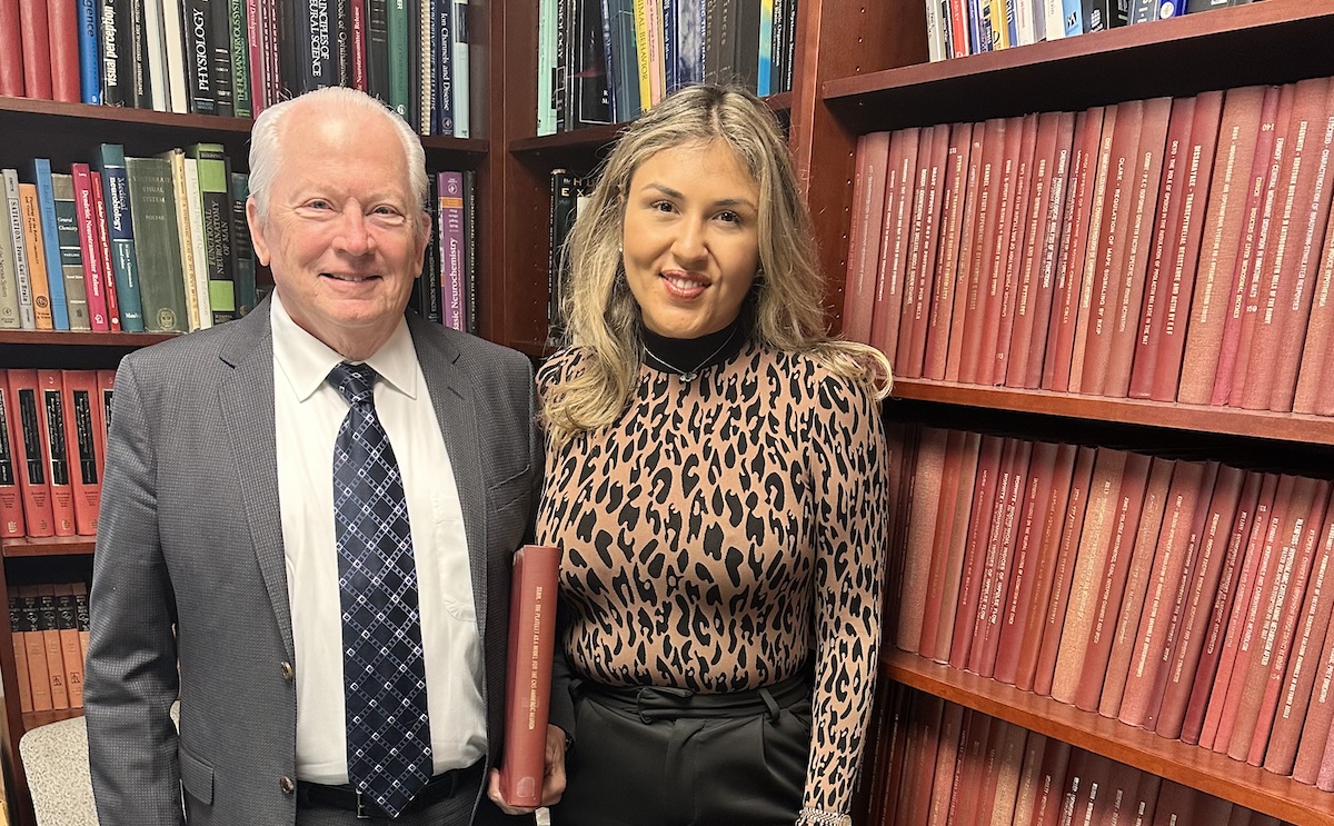 in front of bookcase, 2 people