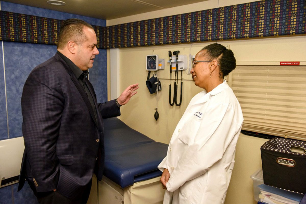 Icy Cade-Bell, MD, medical director of the Pediatric Mobile Medical Unit, (right) gives Alex Pissios, president and CEO of Cinespace Chicago Film Studios, a tour of the unit in January.