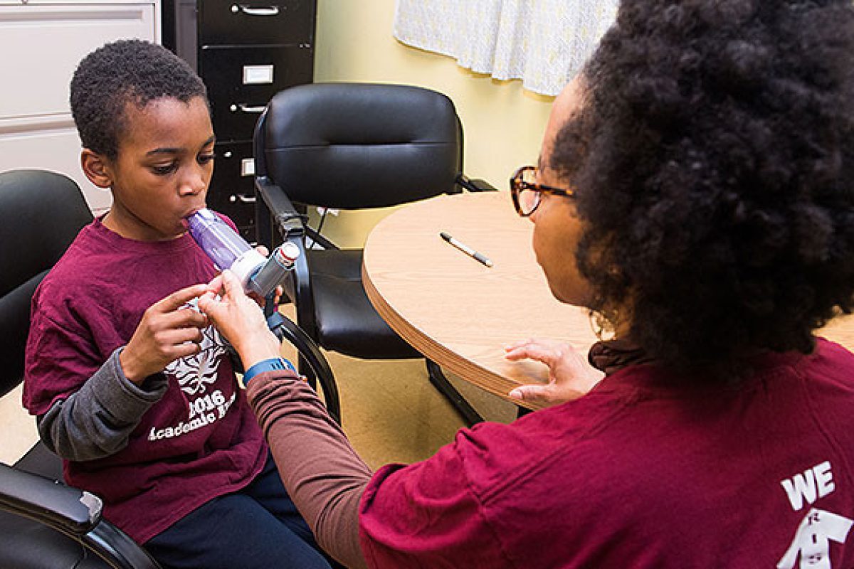 Woman assisting boy with Asthma